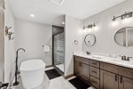 En-suite bathroom with stand up shower, tub, and double vanity